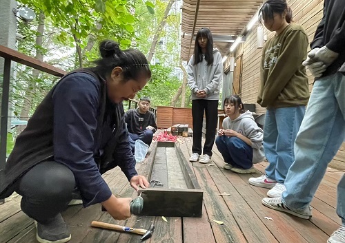 北科大建築系兼任老師林清俊（左）帶領學生運用廢棄木棧板製作植栽盒。