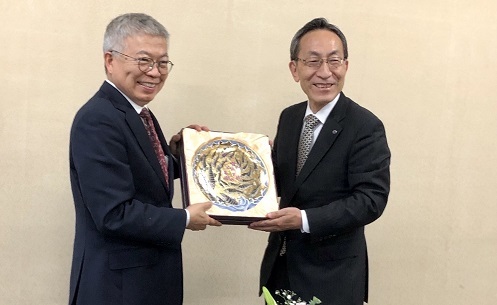 校長王錫福（左）致贈陶瓷彩繪盤予東北大學校長大野英男。