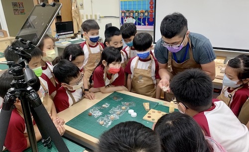 麗山國小學生線上線下同步進行木育課程，專注於塗抹木工膠技巧。